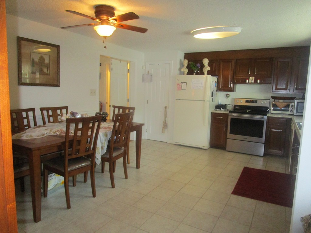 23 Oak Street, Unit E Methuen, MA 01844 - Photo 10 of 26 a kitchen with stainless steel appliances granite countertop a stove a refrigerator a dining table and chairs