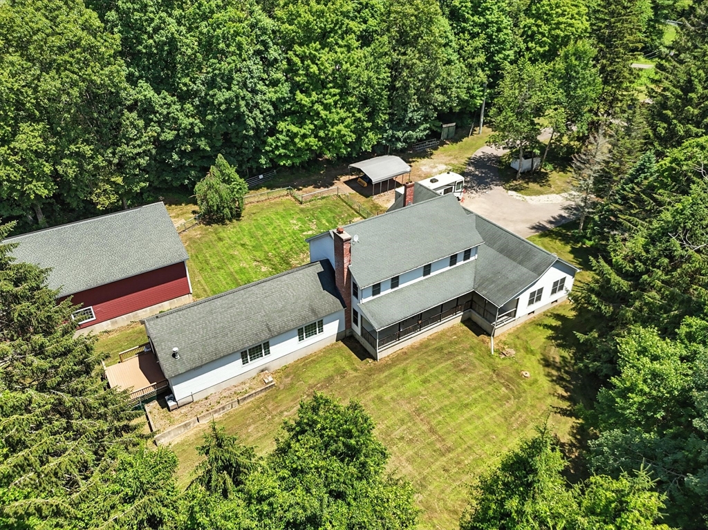 an aerial view of a house with swimming pool and trees
