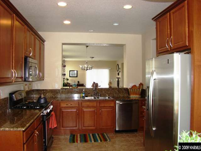 521 Needles Court Reno, NV 89521 - Photo 5 of 9 a kitchen with granite countertop a stove and a refrigerator