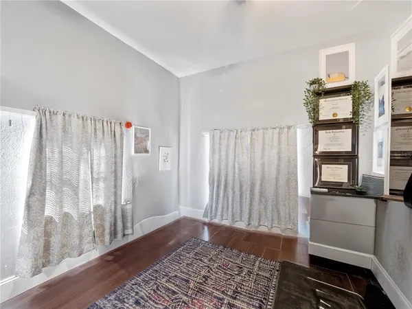 a view of a bedroom with wooden floor and a window