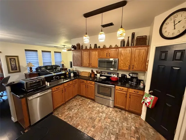 a kitchen with granite countertop a stove and a refrigerator