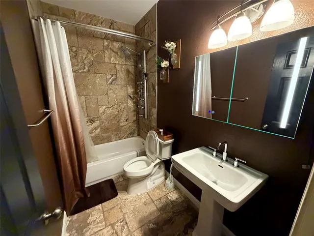 a bathroom with a sink toilet and shower