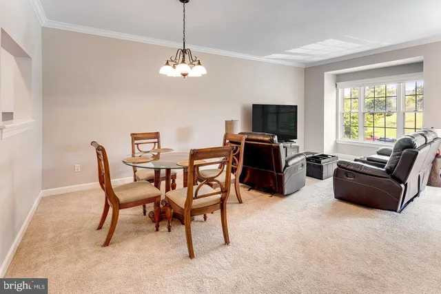 a dining room with furniture a chandelier and wooden floor