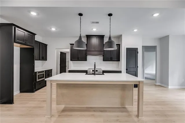an empty room with wooden floor cabinet and windows