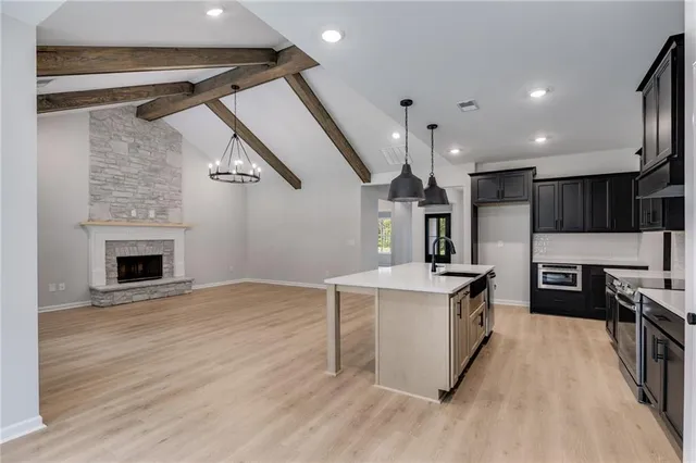a kitchen with kitchen island stainless steel appliances a sink cabinets and refrigerator