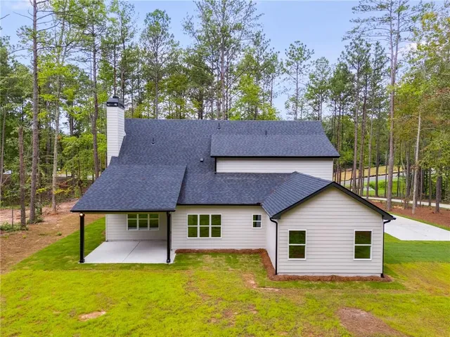 a front view of a house with a yard and trees