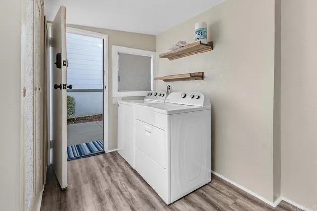 a view of a hallway and closet with wooden floor