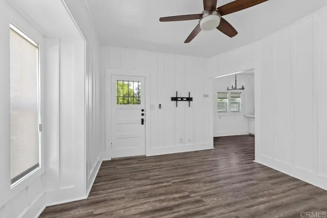 a view of empty room with wooden floor and window