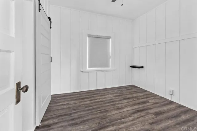 a view of a hallway with wooden floor and closet area