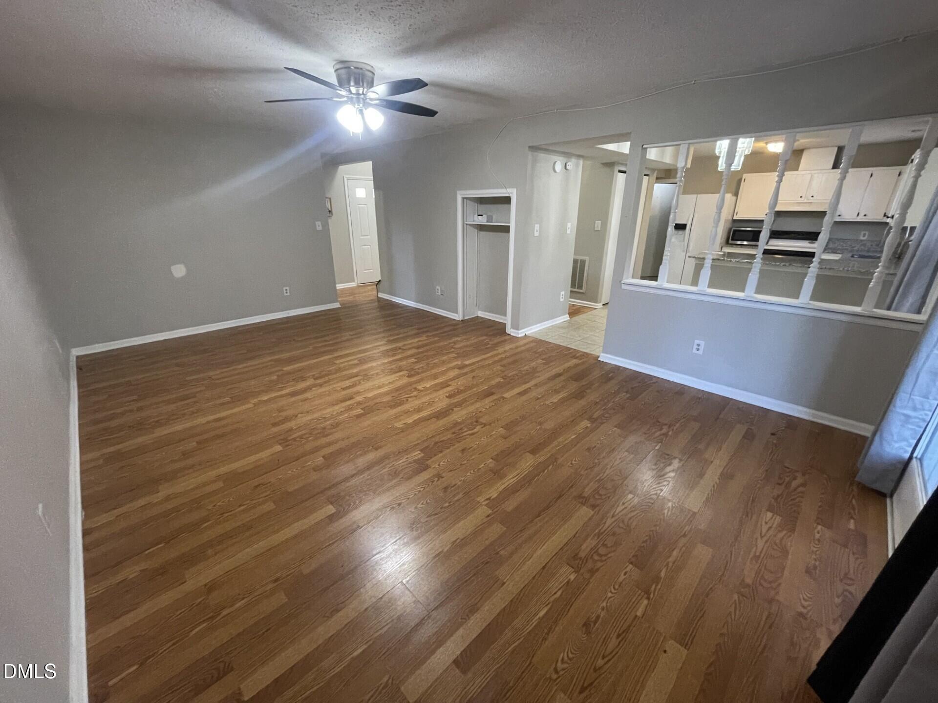 8920 Taymouth Court Raleigh, NC 27613 - Photo 5 of 20 a view of an empty room with window and wooden floor