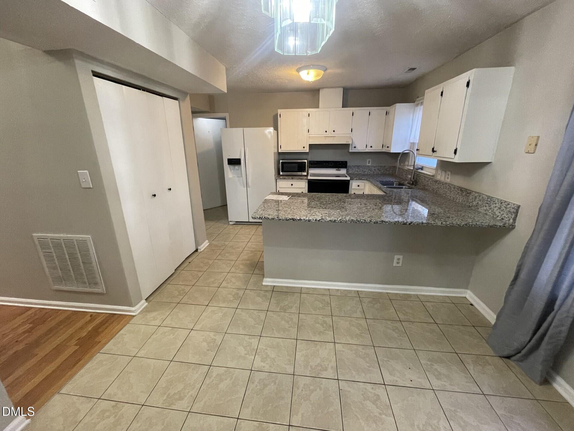 8920 Taymouth Court Raleigh, NC 27613 - Photo 6 of 20 a view of a kitchen with white cabinets
