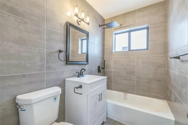 a white bath tub sitting next to a white toilet and a sink