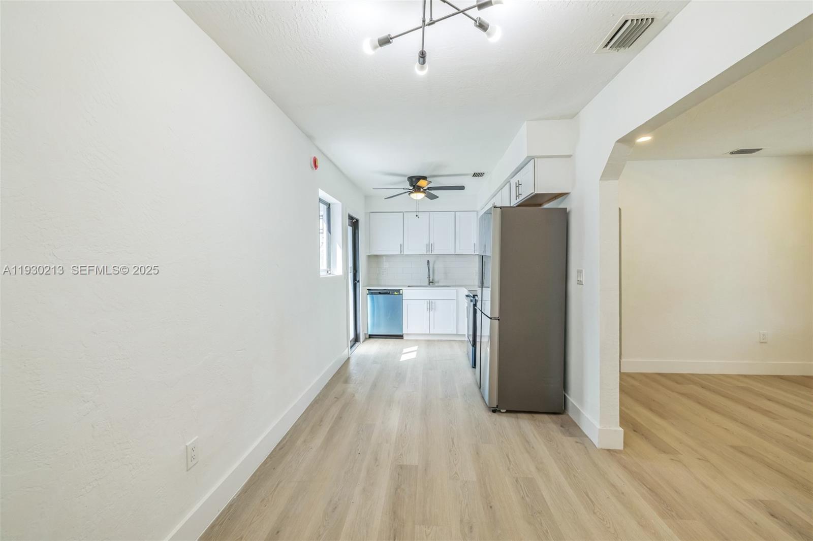9055 Northwest 33rd Avenue Miami, FL 33147 - Photo 11 of 32 a view of a big room with wooden floor and a kitchen