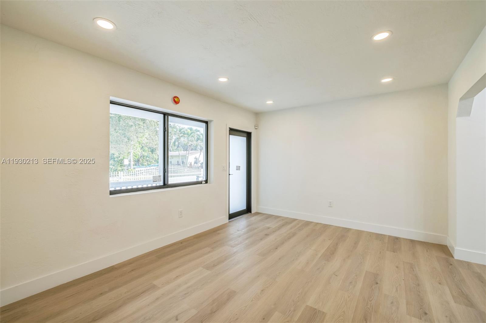 9055 Northwest 33rd Avenue Miami, FL 33147 - Photo 14 of 32 an empty room with wooden floor and windows