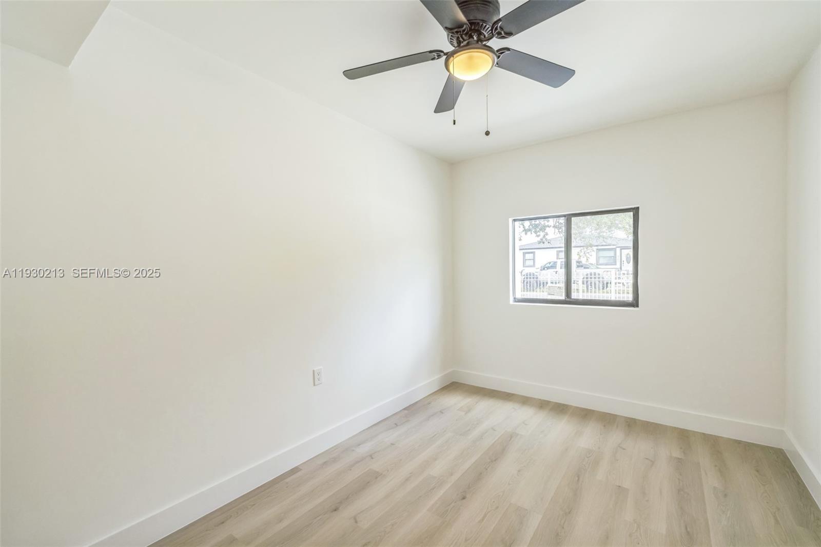9055 Northwest 33rd Avenue Miami, FL 33147 - Photo 22 of 32 an empty room with a window and ceiling fan