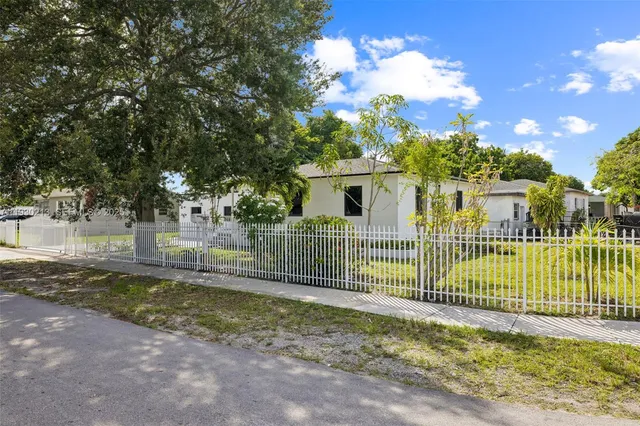 a view of a house with a small yard and wooden fence