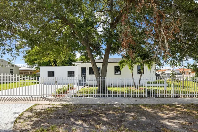 a view of a house with a small yard and fence