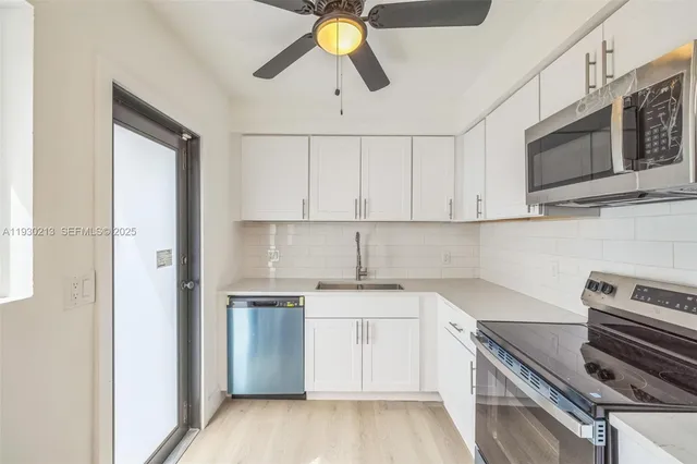 a kitchen with a sink stainless steel appliances and cabinets