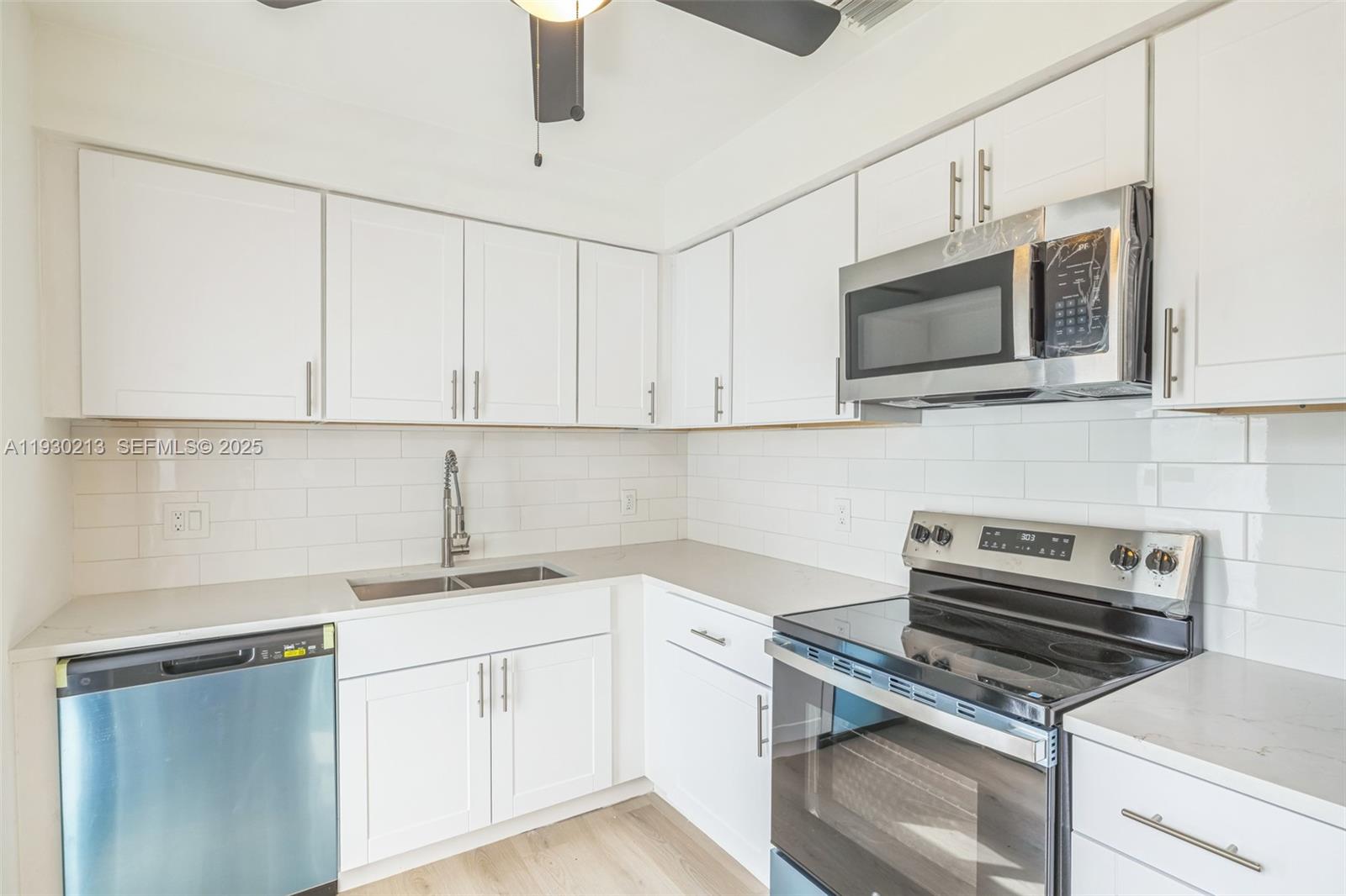 9055 Northwest 33rd Avenue Miami, FL 33147 - Photo 5 of 32 a kitchen with cabinets stainless steel appliances a sink and a microwave