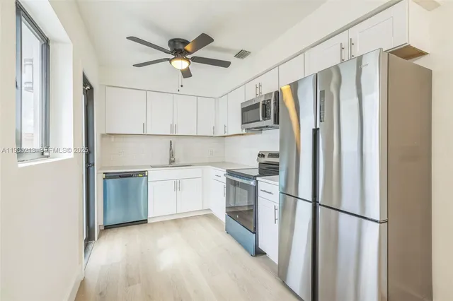 a kitchen with stainless steel appliances a refrigerator and a stove top oven