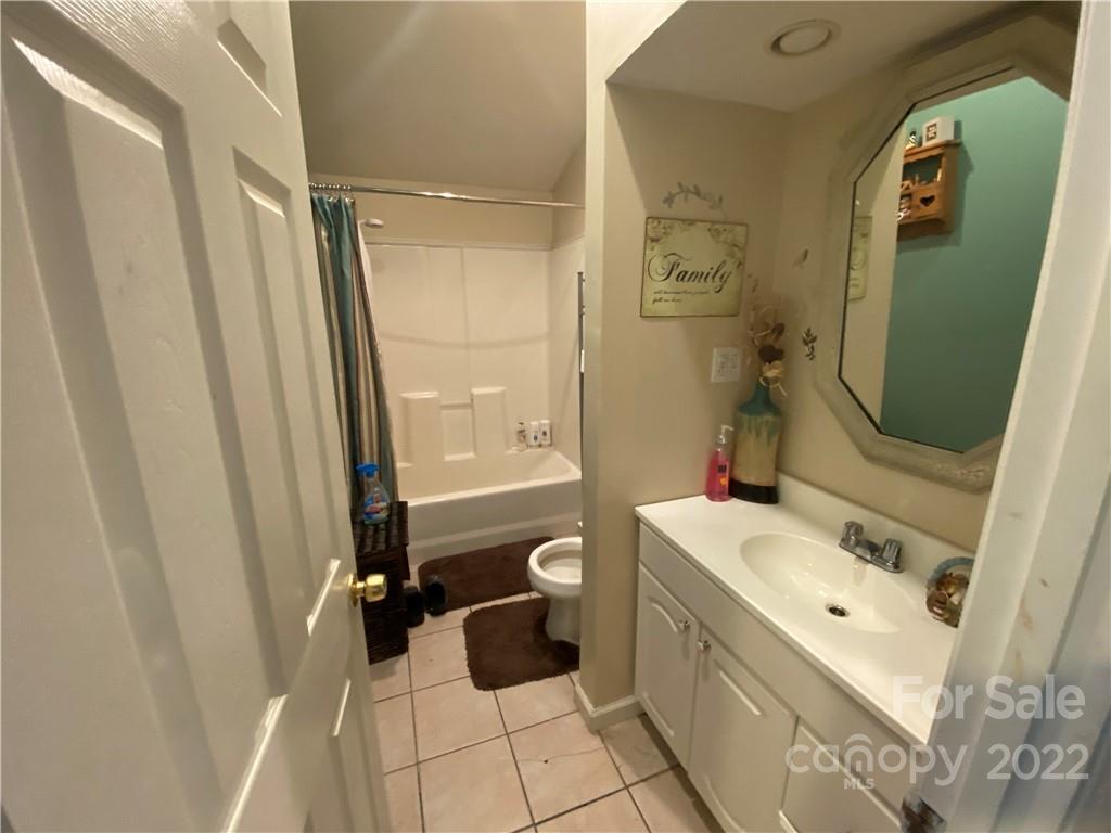 254 Landrum Road Tryon, NC 28782 - Photo 16 of 24 a bathroom with a tub sink toilet and mirror