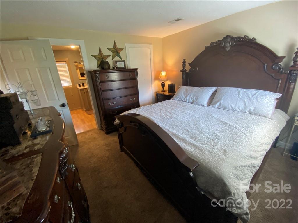 254 Landrum Road Tryon, NC 28782 - Photo 18 of 24 a bedroom with a bed and wooden floor