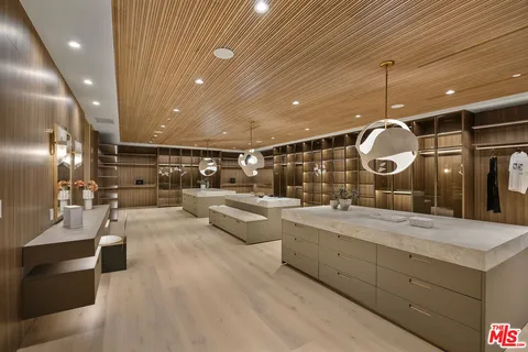 a spacious bedroom with a bed and glass walk in closet
