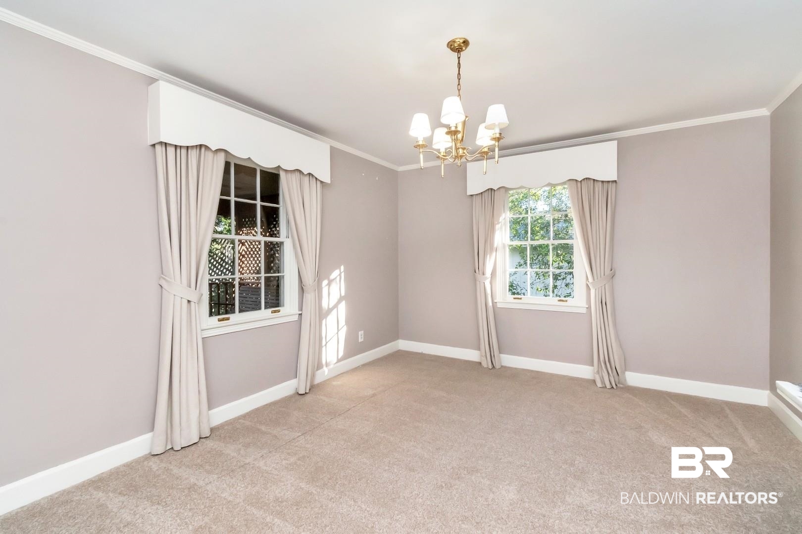 308 Brawood Drive Mobile, AL 36608 - Photo 5 of 33 Unfurnished room featuring light colored carpet, crown molding, and a notable chandelier