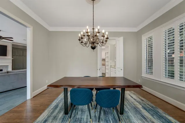 a view of a dining room with furniture a chandelier and wooden floor