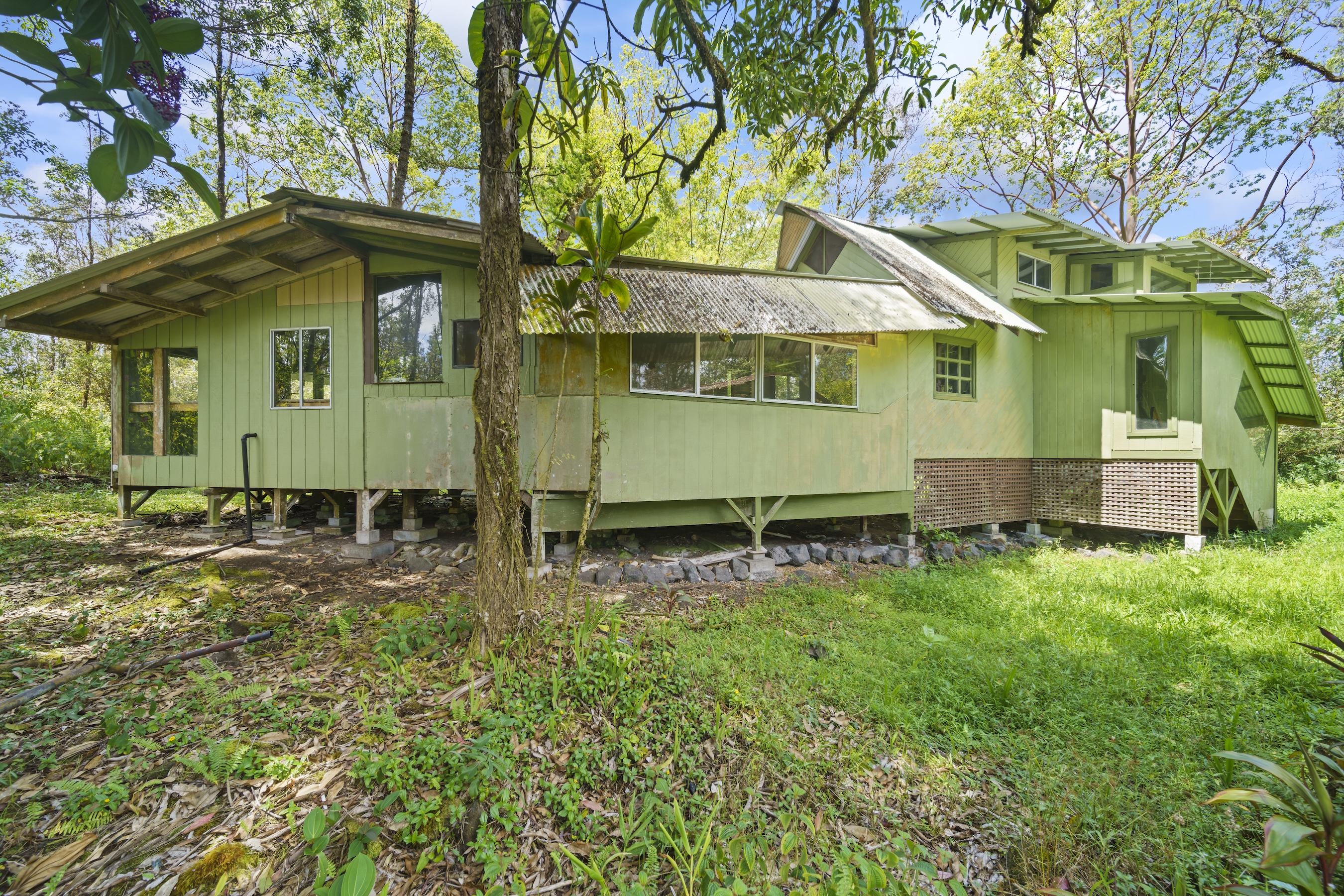16-1857 Hopue Road Mountain View, HI 96771 - Photo 1 of 30 a small house is sitting in the middle of a yard