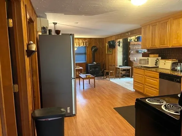 a kitchen with stainless steel appliances granite countertop a stove a sink and a microwave