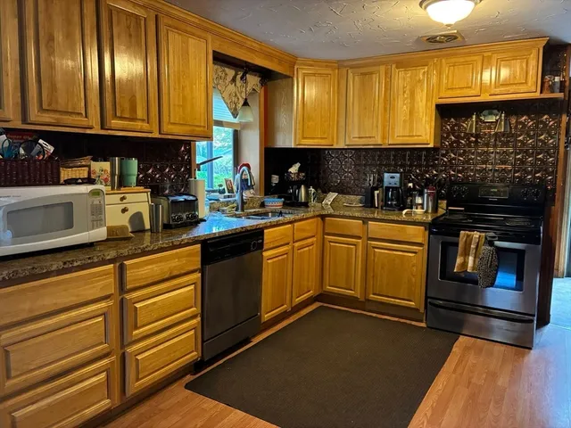 a kitchen with stainless steel appliances granite countertop a refrigerator a stove and a sink