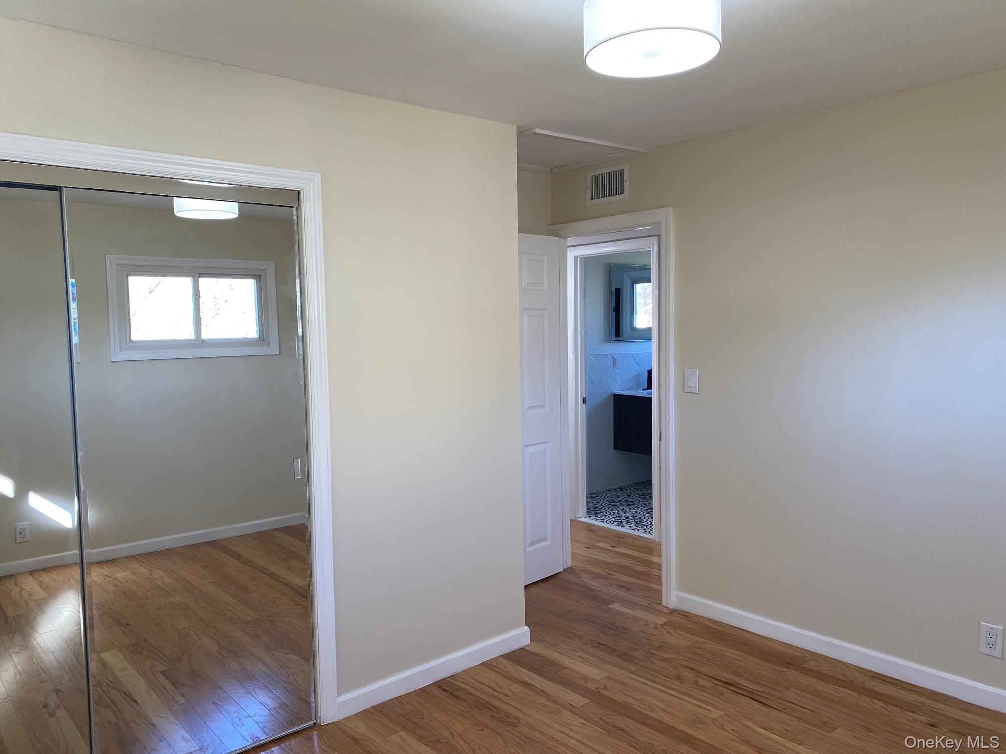 5 Smith Road Cornwall, NY 12518 - Photo 27 of 32 Unfurnished bedroom featuring light wood-type flooring, multiple windows, and a closet