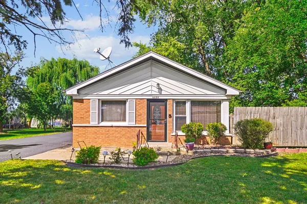 a front view of a house with a garden and plants