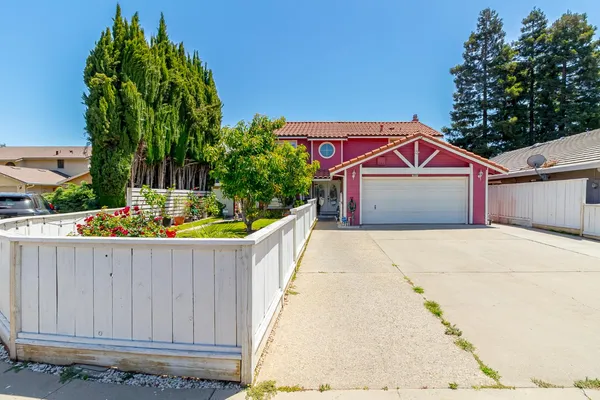 a front view of a house with a garage and a fountain