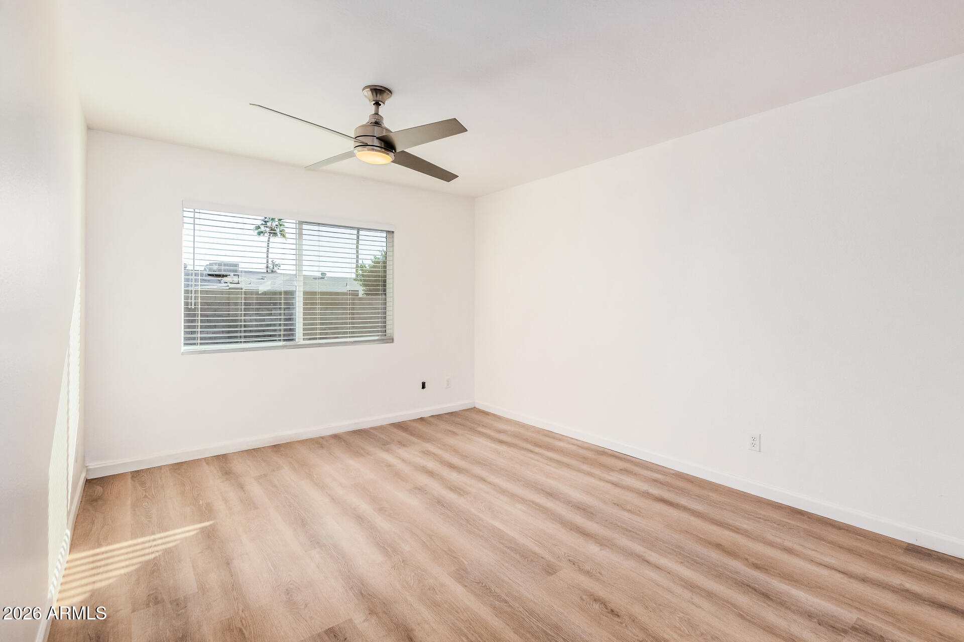 11009 South Tewa Street Phoenix, AZ 85044 - Photo 10 of 26 a view of empty room with wooden floor and fan