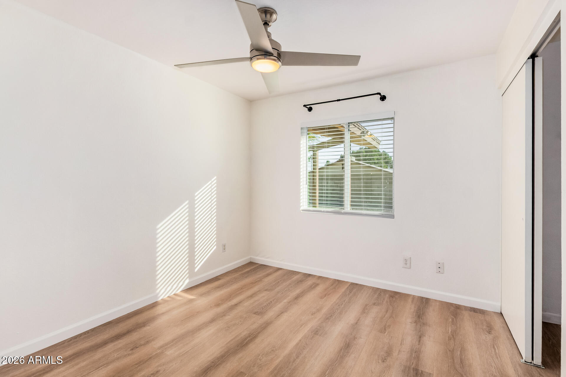 11009 South Tewa Street Phoenix, AZ 85044 - Photo 15 of 26 an empty room with wooden floor and windows
