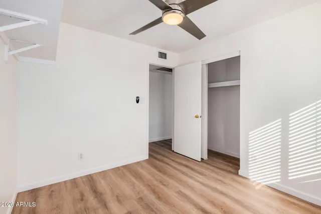 a view of an empty room with a window and a ceiling fan