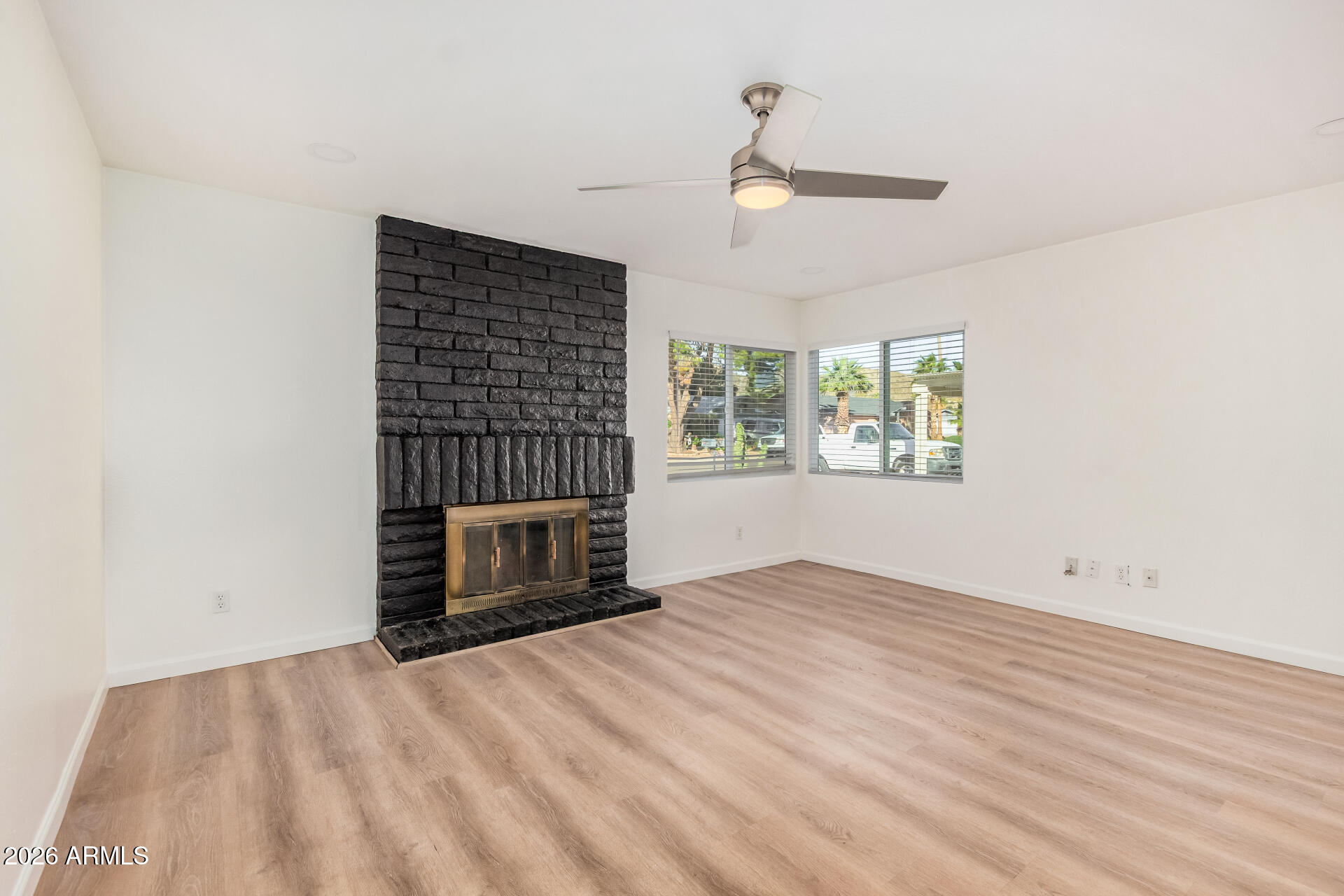 11009 South Tewa Street Phoenix, AZ 85044 - Photo 4 of 26 an empty room with a fireplace and windows