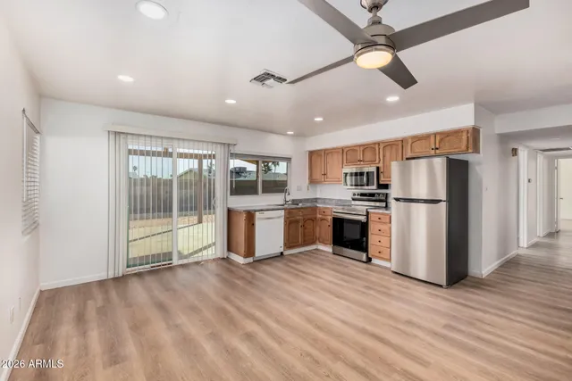 an empty room with a window and ceiling fan