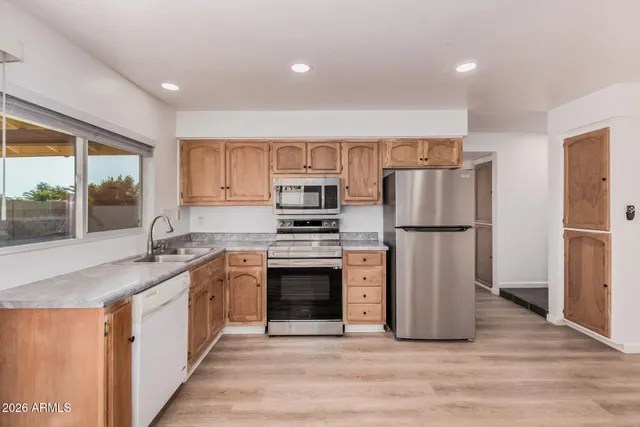 a kitchen with stainless steel appliances a refrigerator sink and cabinets