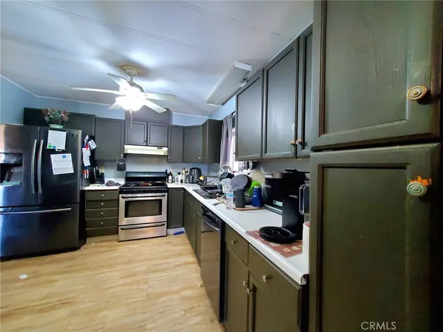 a kitchen with kitchen island a counter top space a sink appliances and cabinets