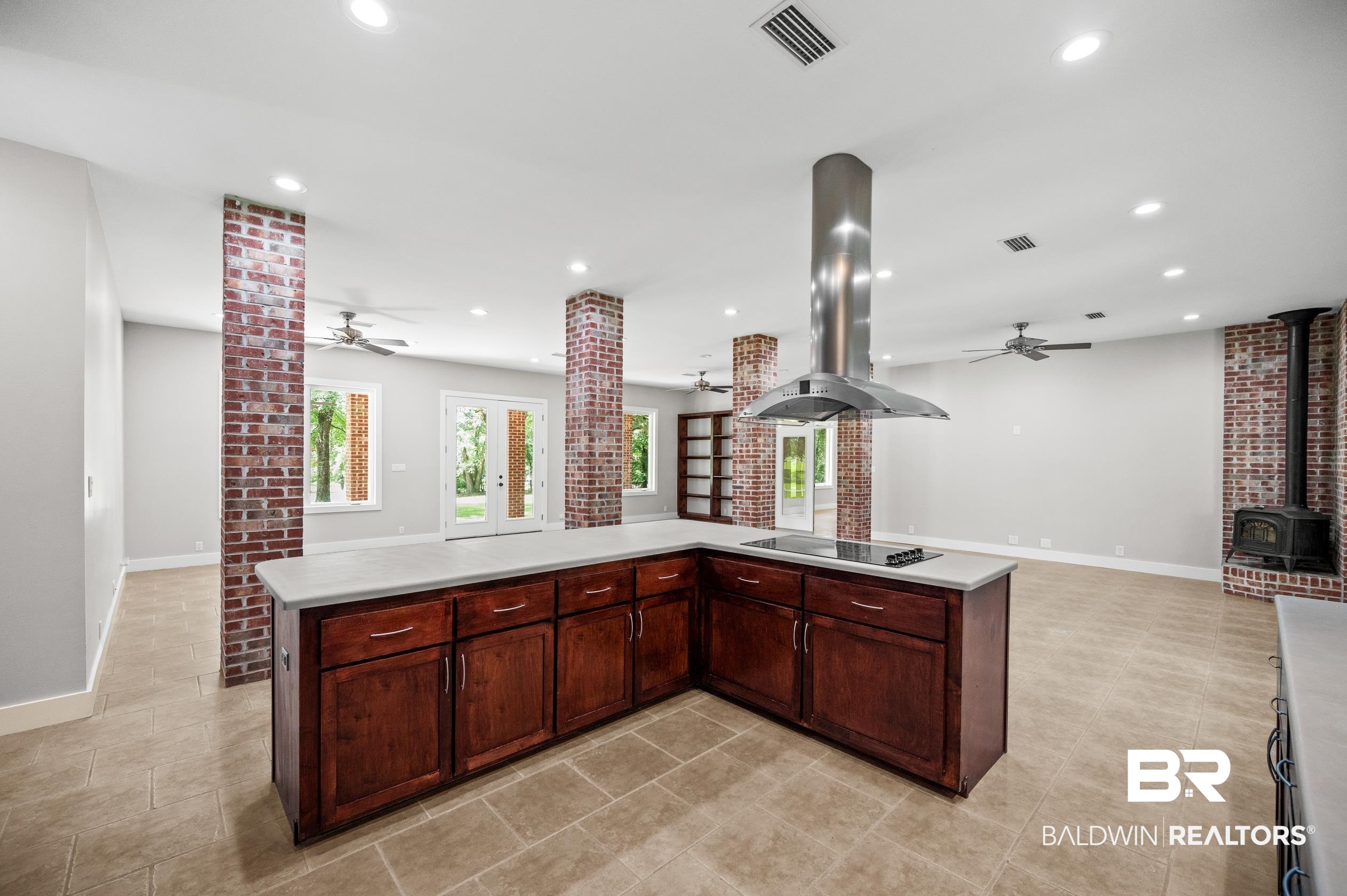 15031 Timber Ridge Drive Loxley, AL 36551 - Photo 15 of 43 Kitchen featuring light tile patterned flooring, a wood stove, island range hood, and ceiling fan