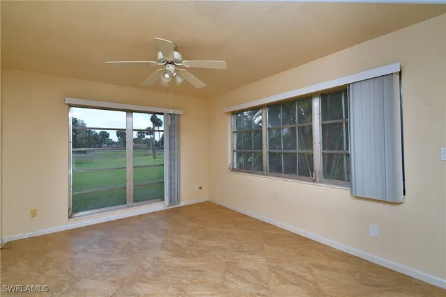 an empty room with a ceiling fan and a window