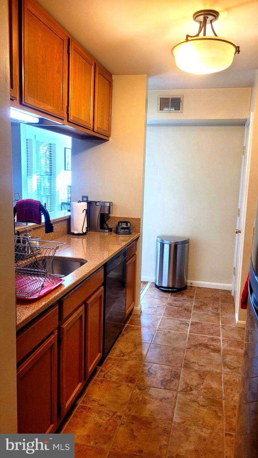 2061 Alice Avenue, Unit 2061303 Oxon Hill, MD 20745 - Photo 3 of 13 a kitchen with stainless steel appliances granite countertop a sink stove and cabinets