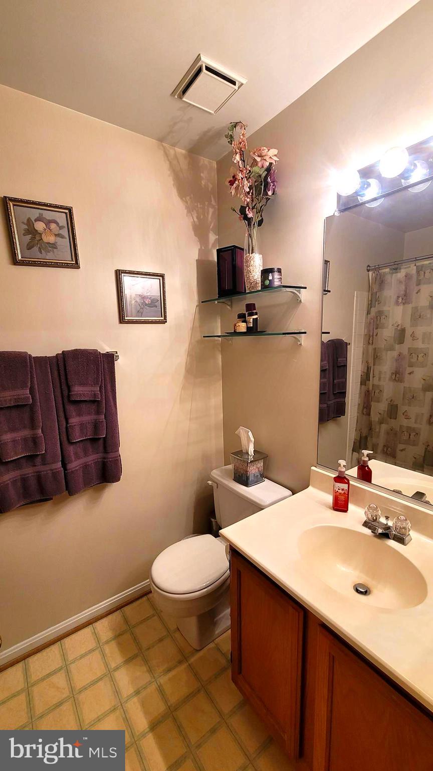 2061 Alice Avenue, Unit 2061303 Oxon Hill, MD 20745 - Photo 9 of 13 a bathroom with a sink a toilet and mirror