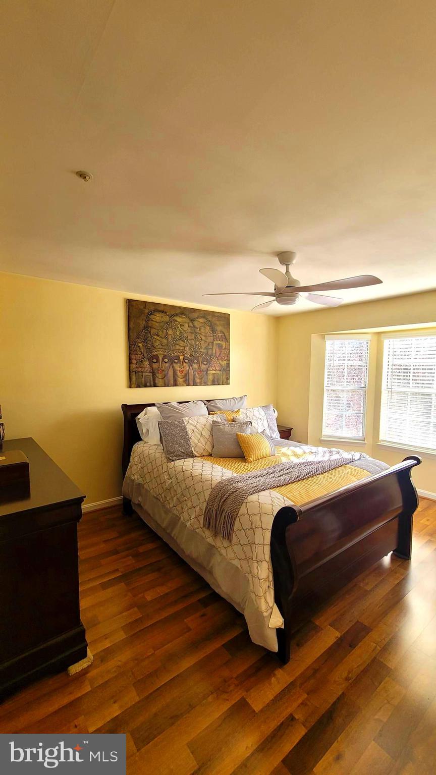 2061 Alice Avenue, Unit 2061303 Oxon Hill, MD 20745 - Photo 10 of 13 a bedroom with a bed and wooden floor