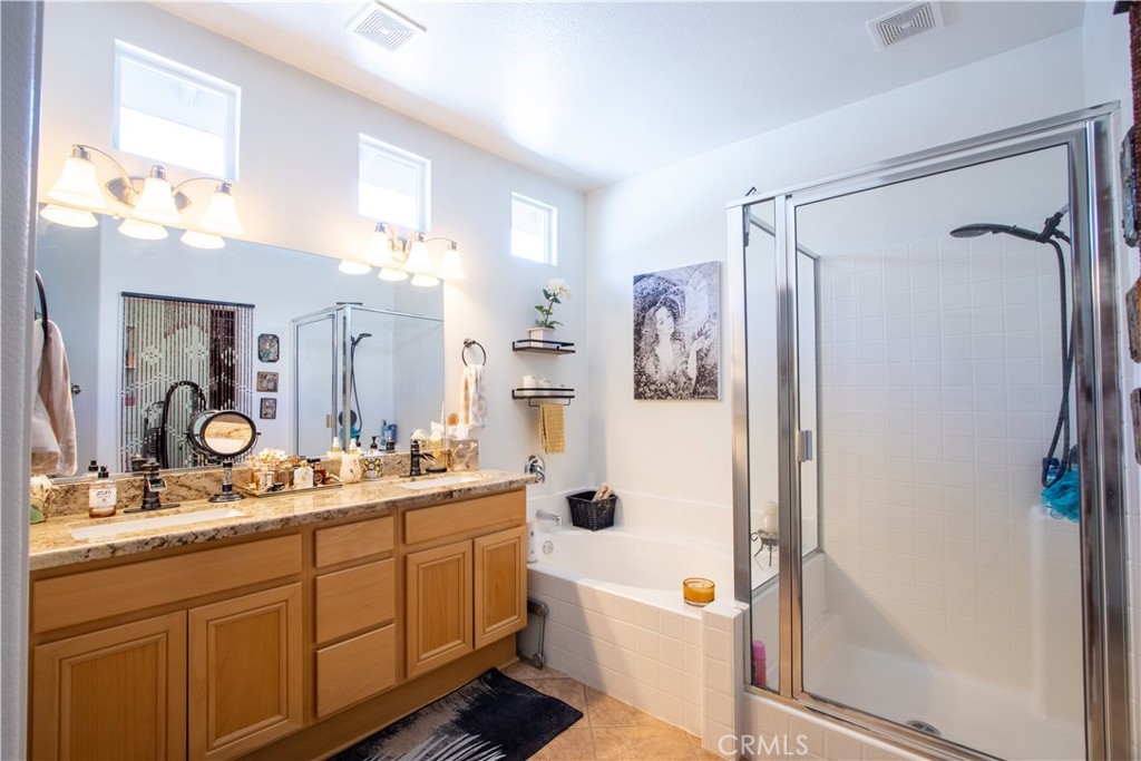 27929 Crystal Spring Drive Menifee, CA 92584 - Photo 23 of 50 a bathroom with a double vanity sink mirror bathtub and shower
