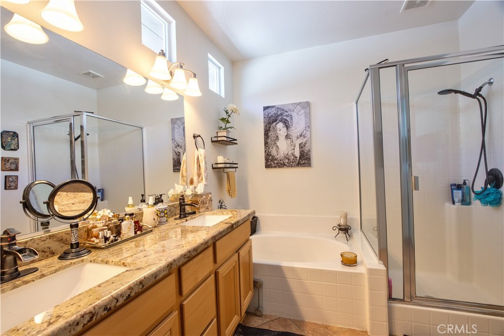 27929 Crystal Spring Drive Menifee, CA 92584 - Photo 24 of 50 a bathroom with a tub sink and mirror