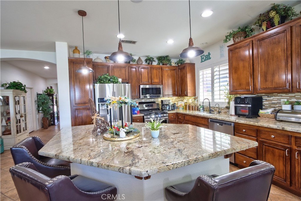 27929 Crystal Spring Drive Menifee, CA 92584 - Photo 10 of 50 a kitchen with stainless steel appliances granite countertop a refrigerator a sink dishwasher a couches and kitchen countertops with wooden floor